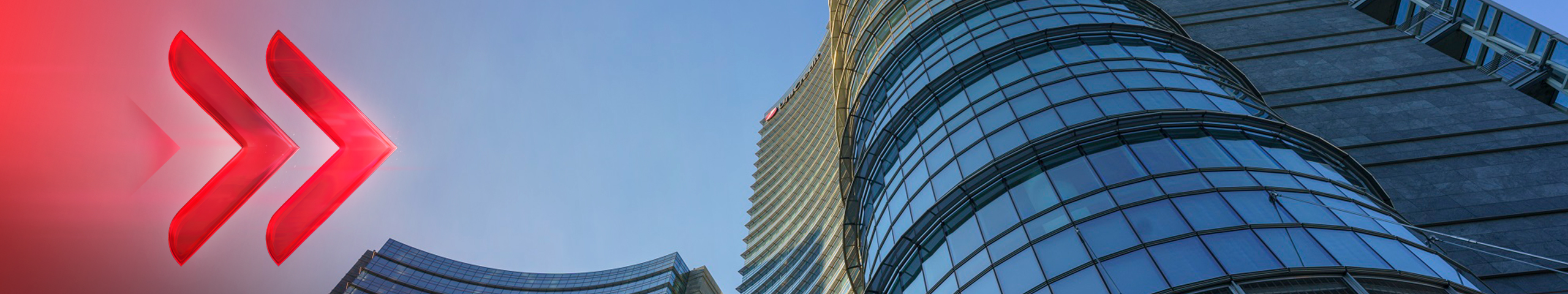 Due frecce rosse stilizzate puntano verso moderni edifici in vetro e acciaio sotto un cielo azzurro.