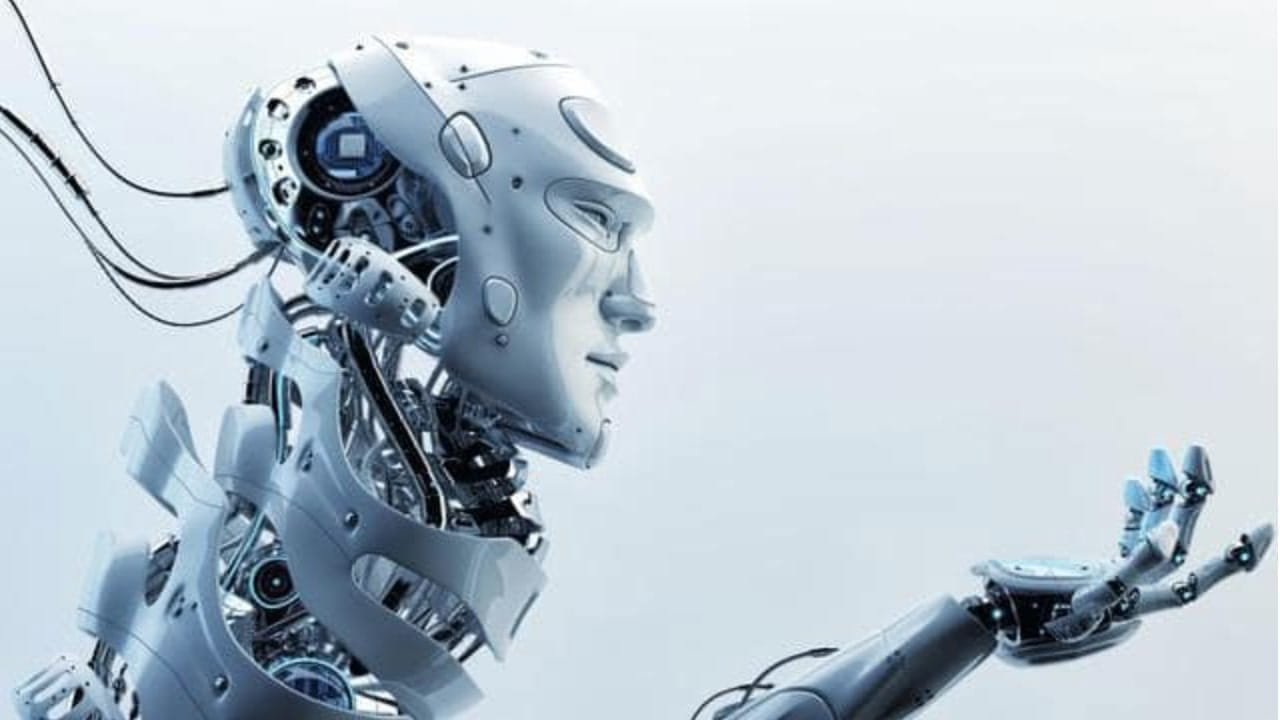 Un robot umanoide con parti meccaniche esposte allunga la mano in avanti, come se osservasse o cercasse di raggiungere qualcosa, su uno sfondo semplice e chiaro.