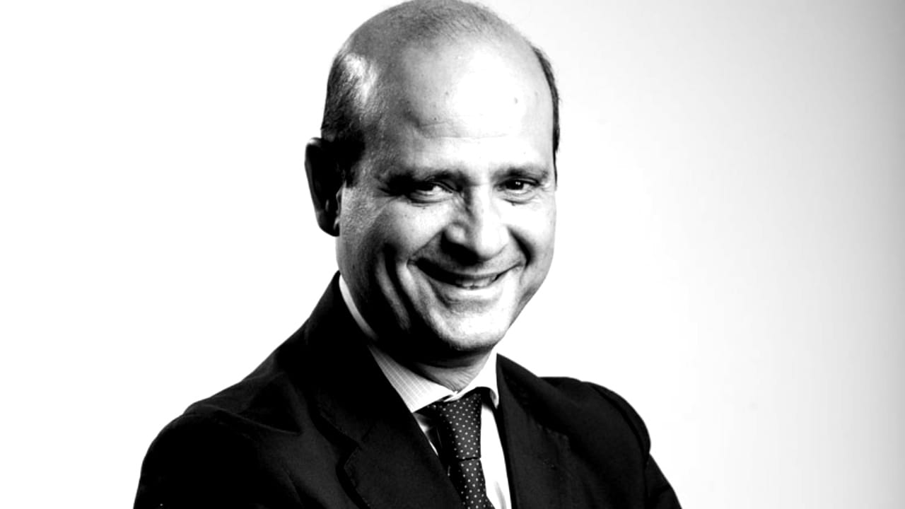 Fabrizio Greco di Banca Cesare Ponti, foto in bianco e nero di uomo elegante in giacca cravatta e camicia chiara, testa calva, sorridente