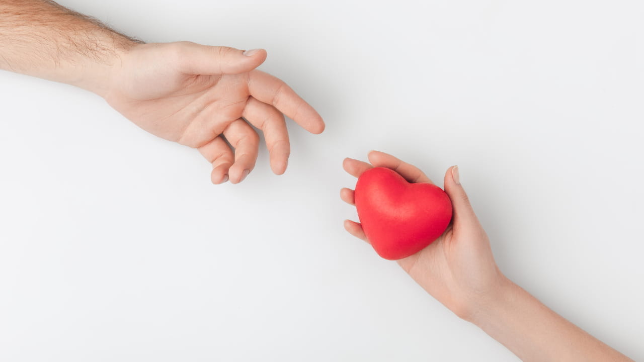 Immagine di un cuore che passa da una mano all'altra per ricordare la filantropia nelle imprese familiari.