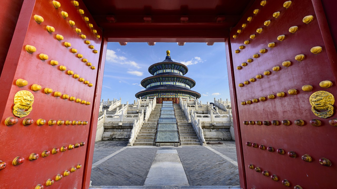 I cancelli rossi si aprono per rivelare il Tempio del Cielo a Pechino, in Cina. L'immagine vuole richiamare l'idea degli investimenti finanziari, in particolare delle azioni che sono cresciute molto negli ultimi mesi