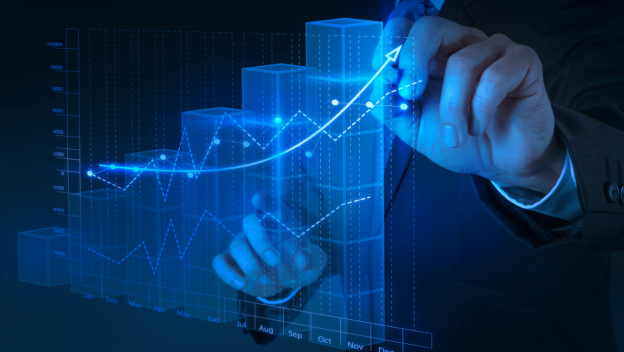 Una persona in giacca e cravatta interagisce con un grafico digitale, che indica la crescita del mercato. Il grafico presenta barre crescenti e una linea con punti dati, suggerendo un'analisi o una proiezione di trend crescenti nel tempo. Il colore blu brillante domina la scena.