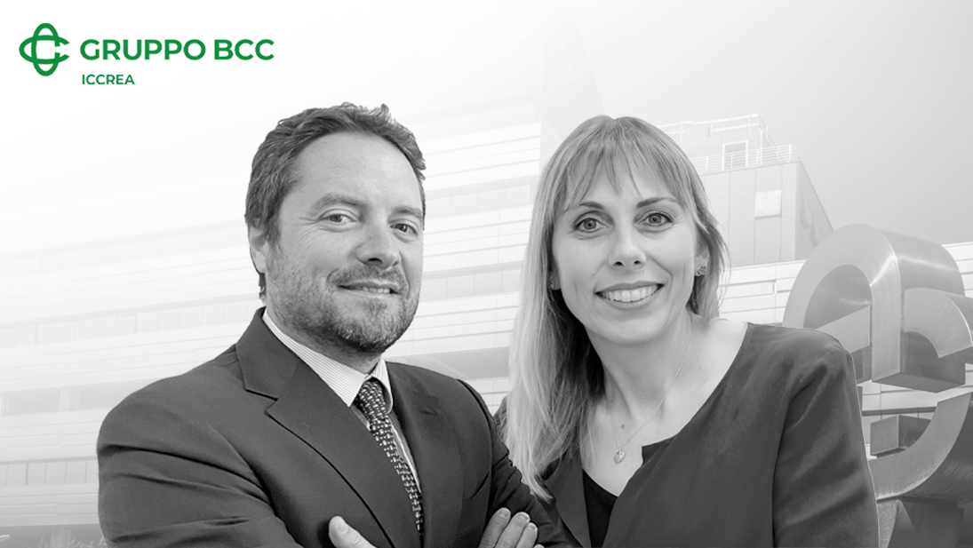 Un uomo e una donna in abiti da lavoro stanno in piedi con sicurezza davanti a un edificio moderno, incarnando i valori di educazione finanziaria. Il logo "Gruppo BCC ICCREA" è ben visibile nell'angolo in alto a sinistra.