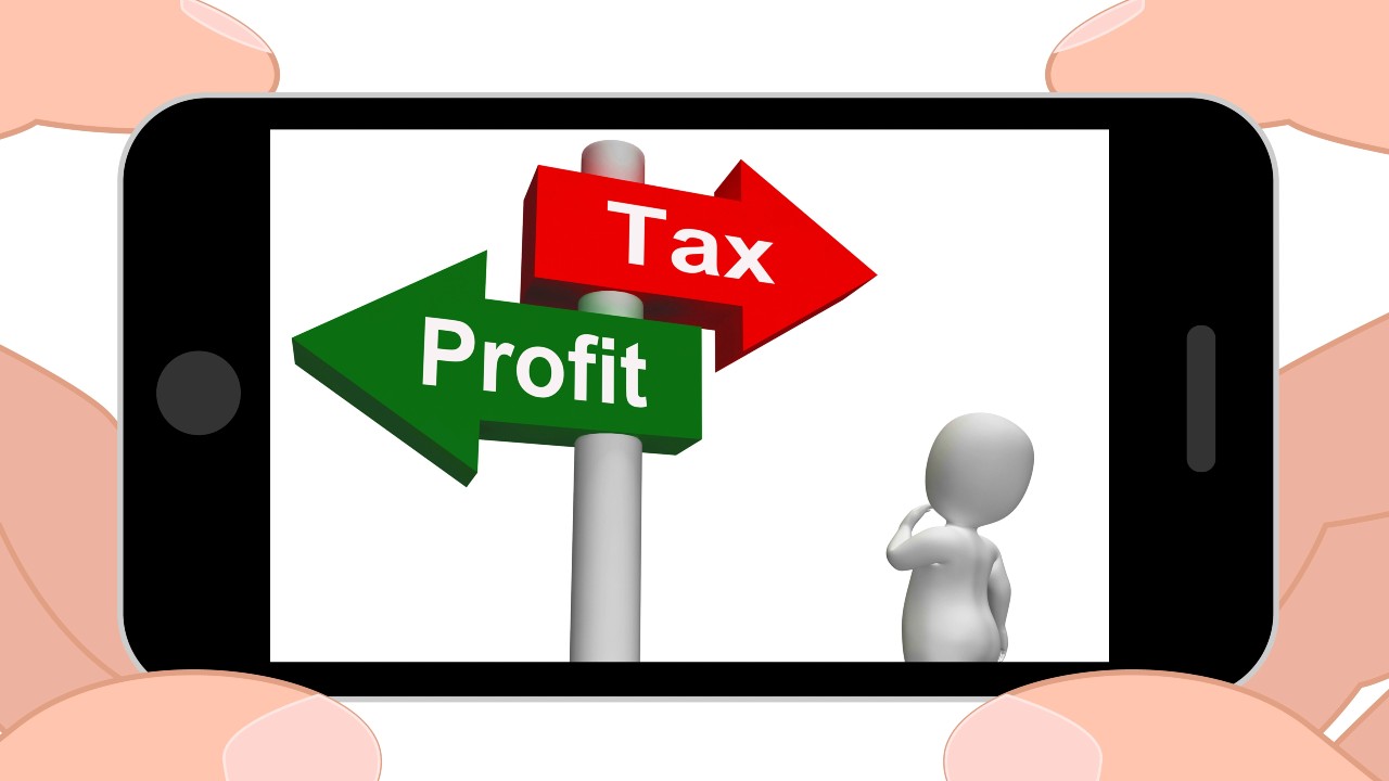Una persona che tiene in mano uno smartphone mostra l'immagine di una piccola figura 3D che contempla due frecce che puntano in direzioni opposte, etichettate "Profit" in verde e "Tax" in rosso. L’immagine si collega all’articolo “Società liquidata e tassazione utili: chi paga in caso di usufrutto?”