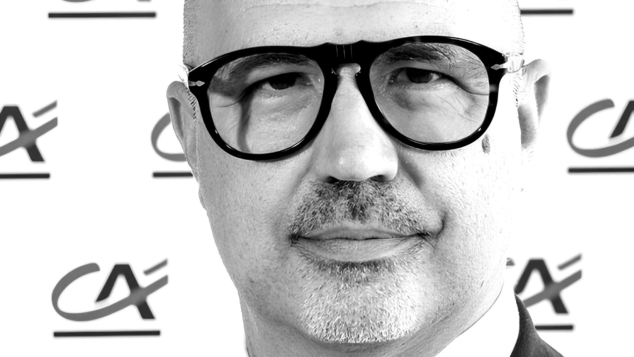 Un'immagine in bianco e nero di Daniele Carullo, che indossa grandi occhiali da vista con una montatura nera