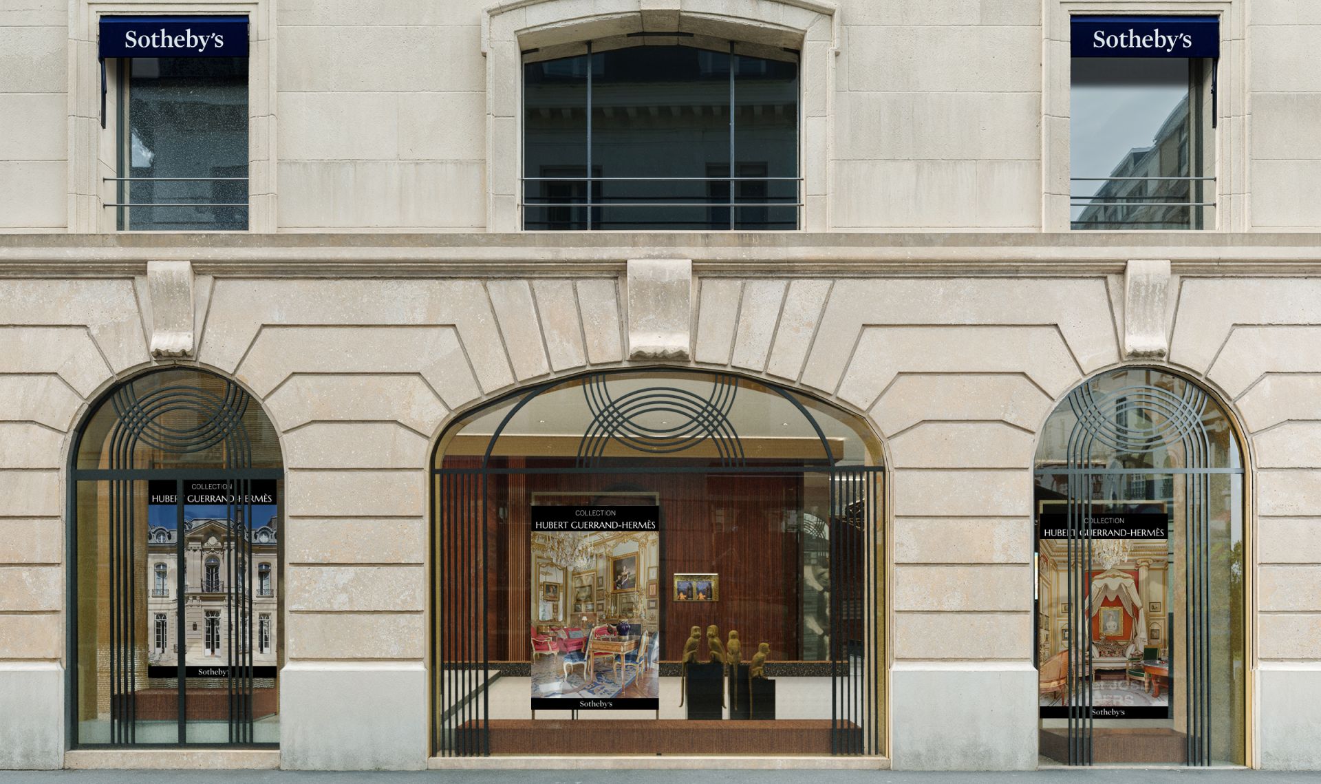 La vista sulla strada di una vetrina di Sotheby's con finestre ad arco offre uno scorcio della sua anima ricca di arte, che ricorda il vibrante fondo culturale di Abu Dhabi. Pezzi incorniciati adornano l'esposizione. La facciata in pietra vanta una finitura beige, completata da due porte e barre decorative alle finestre.