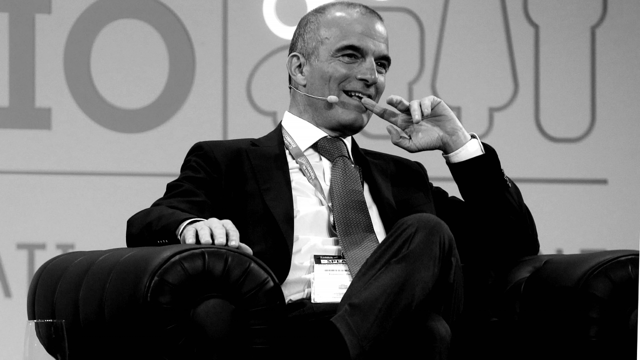 Tommaso Corcos di Fideuram - Intesa Sanpaolo in giacca e cravatta siede comodamente in poltrona, parlando in un microfono con cuffia.