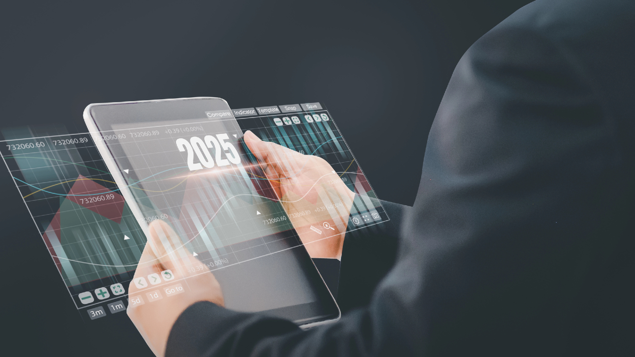 Una persona in giacca e cravatta tiene in mano un tablet trasparente che mostra immagini e grafici di dati futuristici, simili a un portafoglio digitale. L'anno "2025" è evidenziato nell'interfaccia elegante, mentre lo sfondo scuro accentua la grafica luminosa sullo schermo.