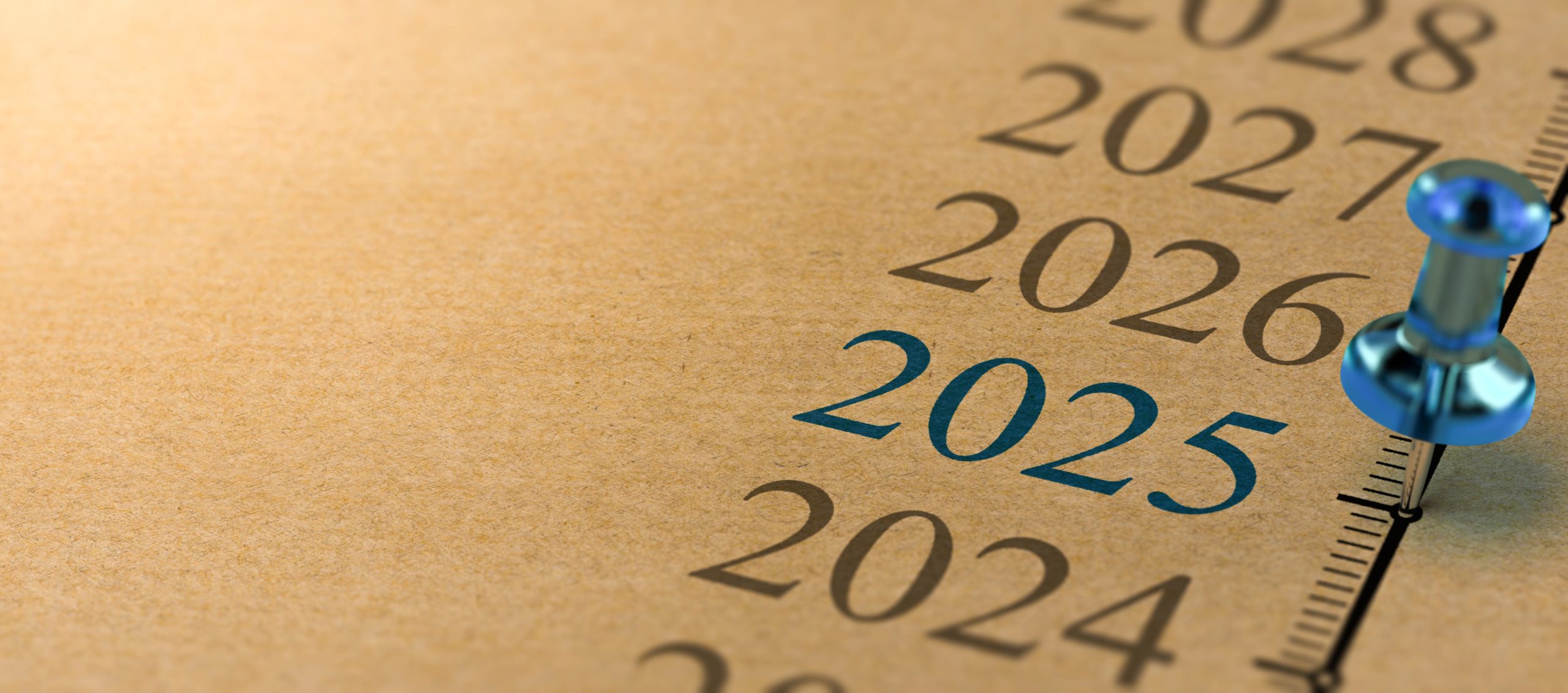 Un'immagine ravvicinata di una pagina beige con un elenco di anni stampato verticalmente, che vanno dal 2021 al 2027. Una puntina blu indica l'anno 2025, evidenziato in carattere blu.