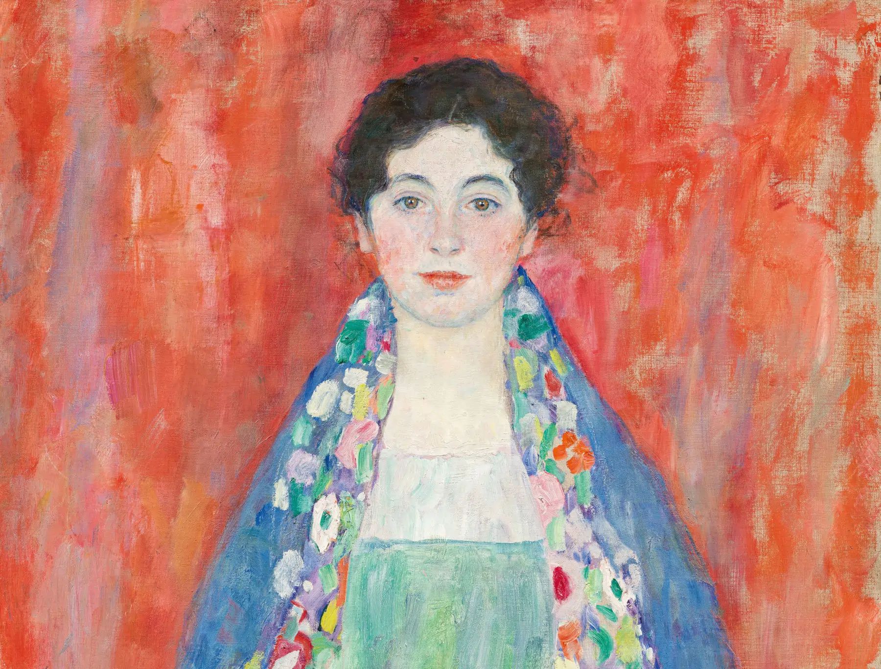 Un ritratto dipinto di una giovane donna con capelli ricci scuri su uno sfondo rosso acceso. Indossa uno scialle con motivi floreali sopra una camicetta bianca e un vestito verde. Questo capolavoro del 2024 è realizzato in uno stile impressionista, incarnando il fascino delle opere d'arte costose.