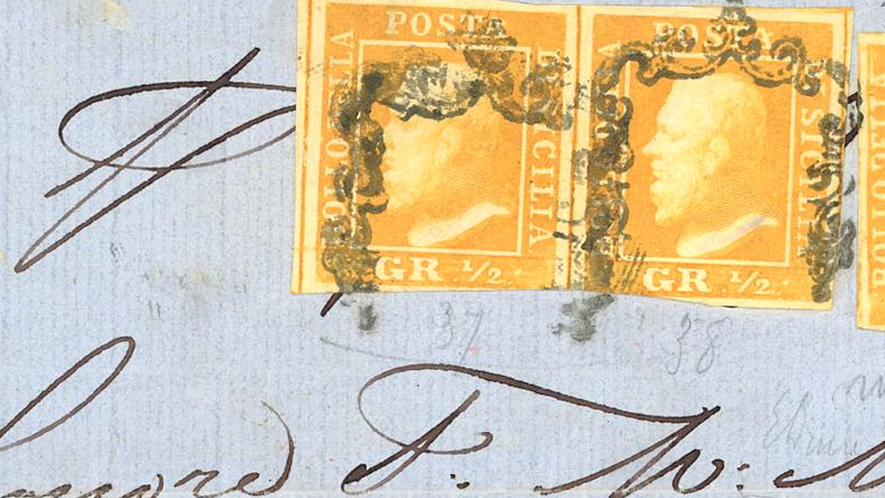 Primo piano di due francobolli vintage arancioni della Sicilia, raffiguranti il profilo di una testa umana. Sono fissati a una busta blu con una grafia in inchiostro nero visibile sotto. I francobolli sono contrassegnati con "POSTA DI SICILIA" e "GR 1/2".