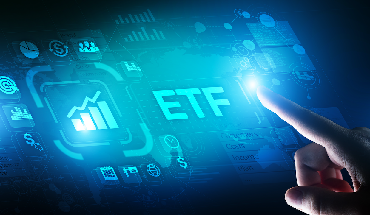 Un dito indica le lettere luminose "ETF" su uno schermo digitale pieno di icone e grafici finanziari, che rappresentano Exchange-Traded Fund e concetti di investimento. Lo sfondo presenta una mappa del mondo in uno schema di colori blu e verde.
