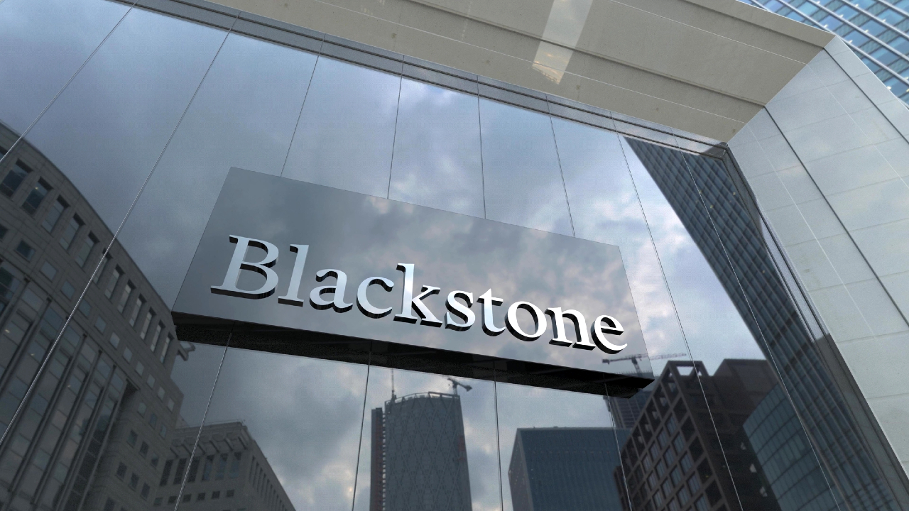 Facciata in vetro di un edificio con una grande insegna con la scritta "Blackstone". L'insegna, incorniciata contro il cielo nuvoloso e i grattacieli adiacenti nel vivace quartiere finanziario, è evidente quanto la presenza di UniCredit nel settore bancario europeo.