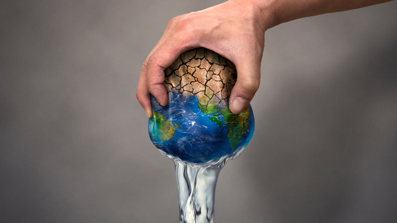 Una mano afferra una Terra screpolata, per metà desolata e per metà vibrante, mentre l'acqua scorre dal fondo. Questa immagine simboleggia lo stress ambientale e la crisi idrica globale, riecheggiando preoccupazioni che persino grandi entità come BlackRock non possono ignorare.