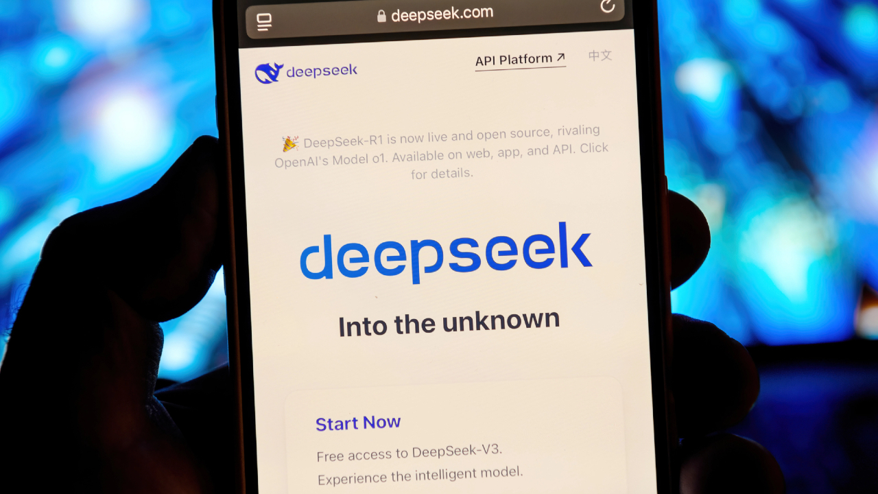 Uno smartphone mostra con eleganza la pagina web "deepseek", adornata dall'intrigante slogan "Into the unknown". Lo schermo invita gli utenti a esplorare l'accesso gratuito a DeepSeek-V3, evidenziando una piattaforma API intuitiva. Luci blu sfocate illuminano dolcemente lo sfondo, accrescendo il mistero.