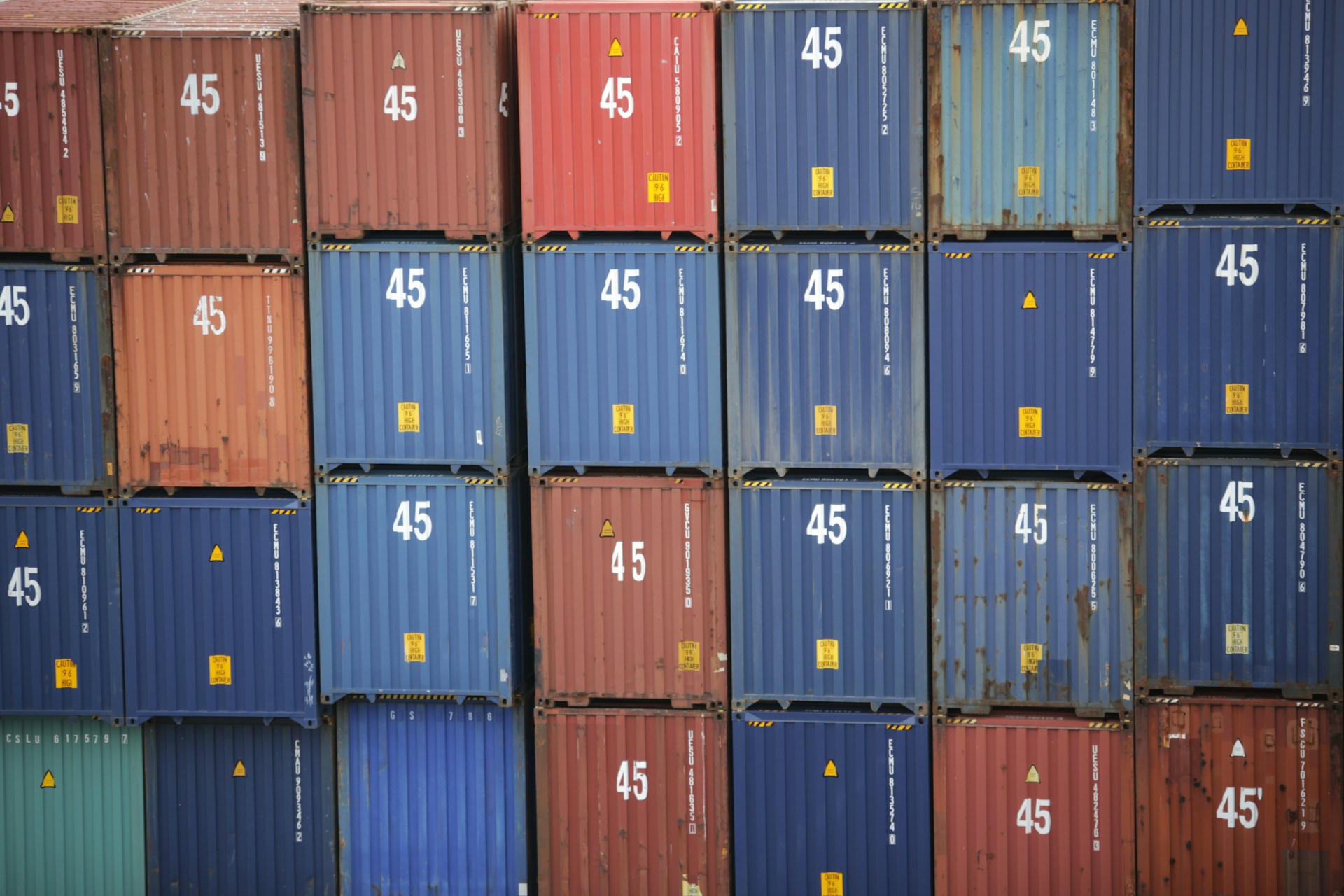 Una pila di container di vari colori, tra cui blu, rosso e marrone, ciascuno etichettato con il numero "45". La disposizione ordinata rispecchia un approccio di investimento strategico, che incarna sia la struttura che la diversità.
