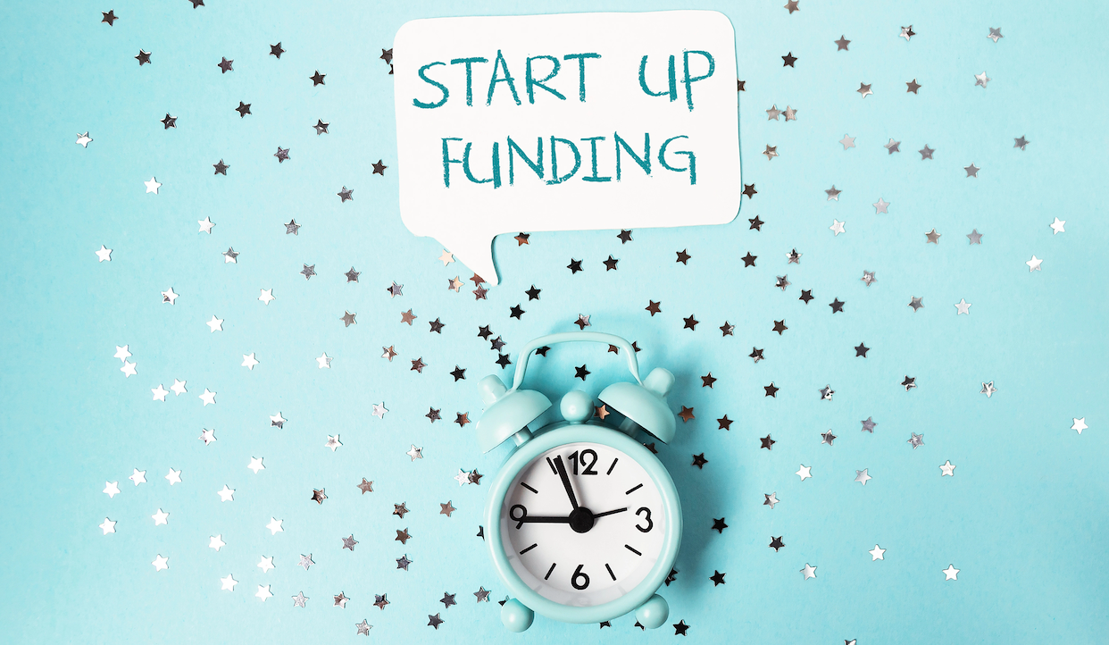 Una piccola sveglia impostata sulle 12 su uno sfondo azzurro con stelle argentate sparse. Sopra, un fumetto recita "START UP FUNDING.
