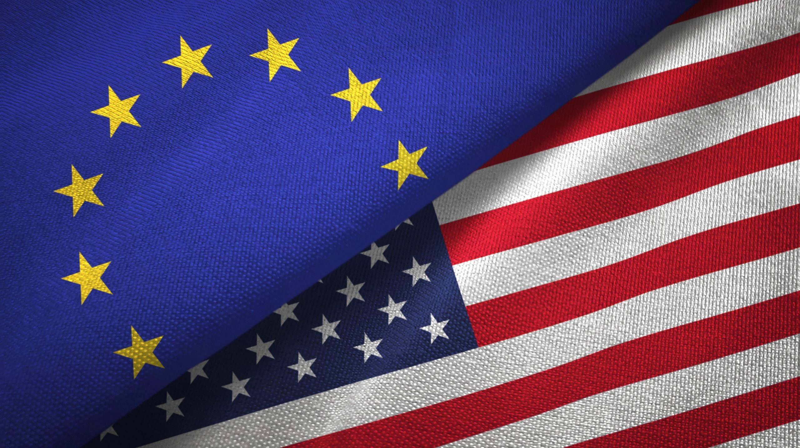 L'immagine ritrae il simbolo dell'unità Europa, con le stelle gialle della bandiera dell'Unione Europea su sfondo blu che si sovrappongono con eleganza alla bandiera degli Stati Uniti, nota per le sue strisce rosse e bianche e le stelle bianche su sfondo blu.