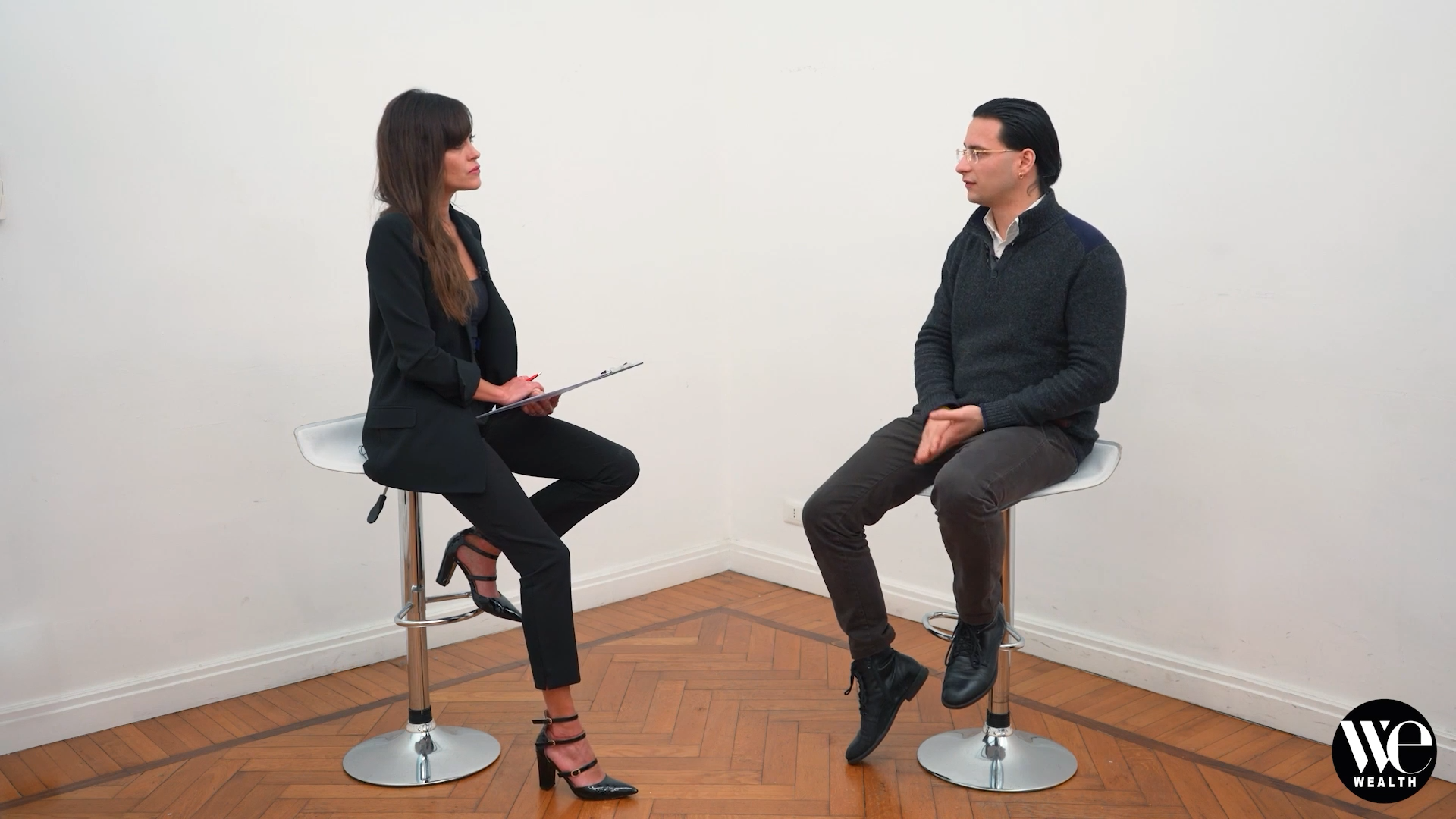 Chiara Samorì e Martino Dallasta sono seduti su degli sgabelli in un ambiente interno, impegnati in una conversazione sul tema della consulenza finanziaria e delle sfide che il settore dovrà affrontare