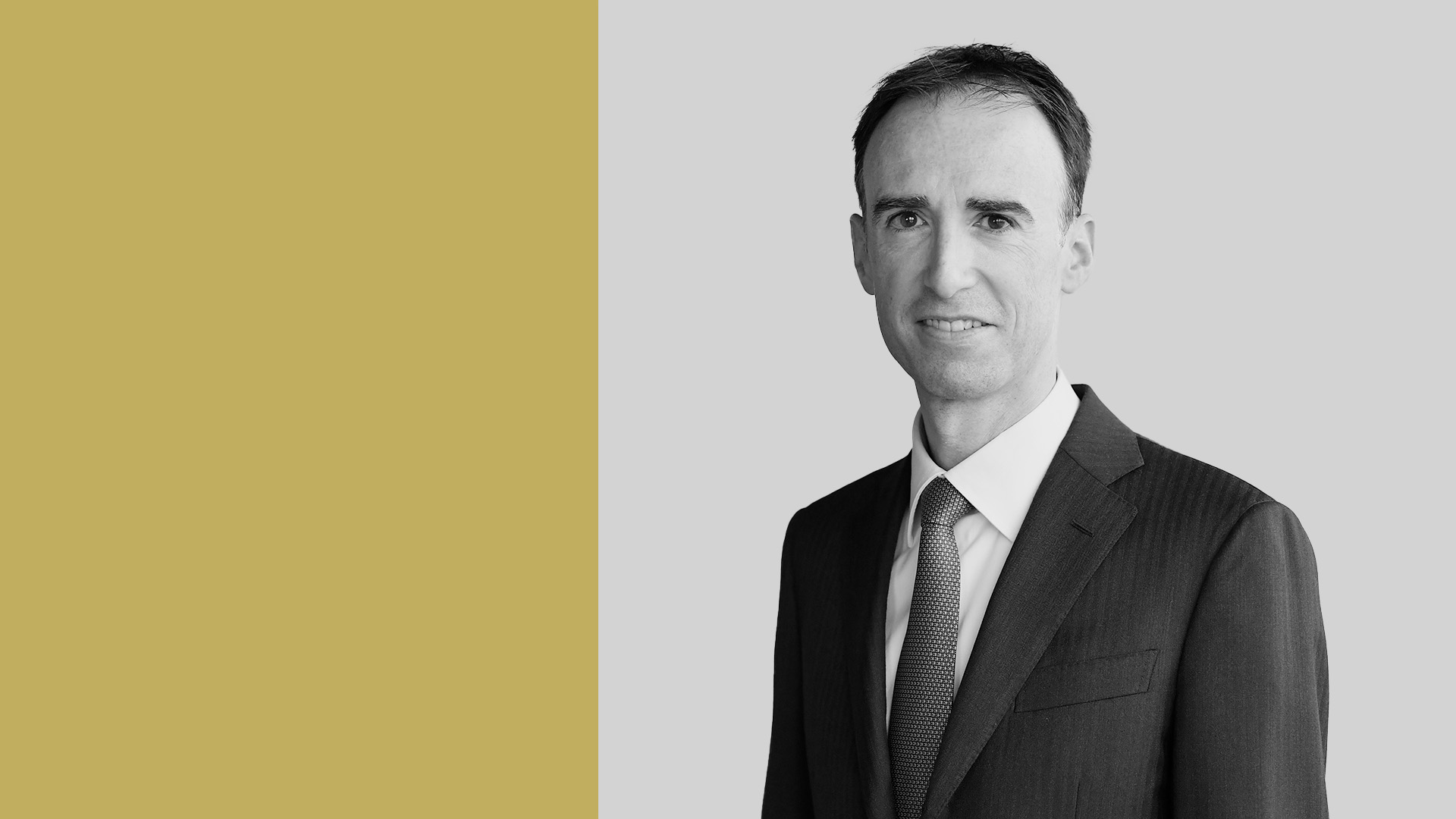 Matteo Botto Poala di Goldman Sachs Am è su uno sfondo diviso in oro e grigio. L'uomo è rivolto in avanti e sorride leggermente.