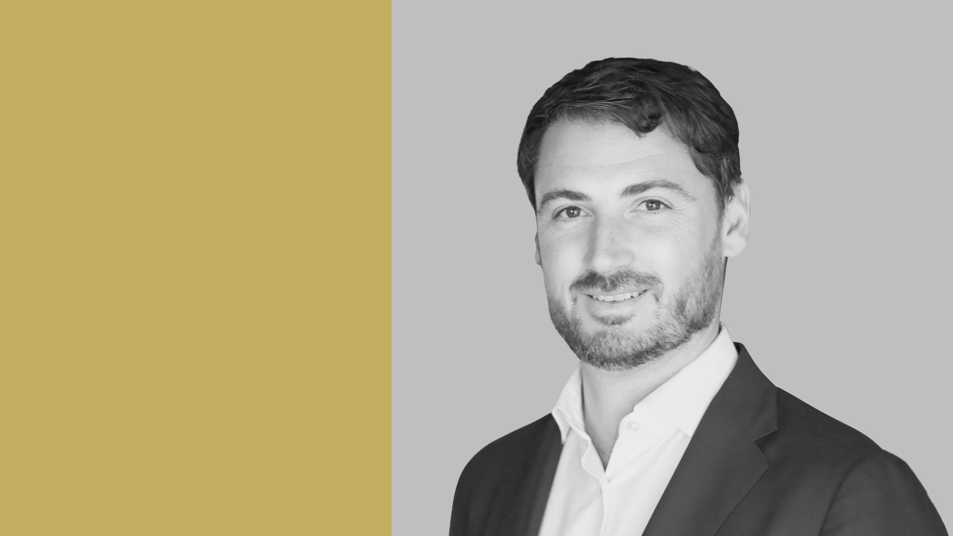 Ritratto in scala di grigi di un uomo in giacca e camicia bianca, che sorride sottilmente. Lo sfondo è diviso tra una sezione giallo senape a sinistra e una sezione grigia a destra, che ricorda il suo ruolo strategico nel private equity.
