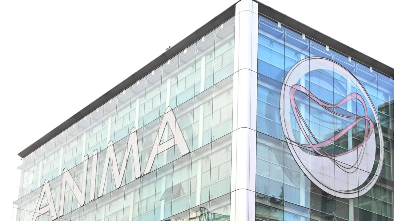 Un moderno edificio in vetro con la scritta "ANIMA" e un grande logo circolare con un'onda stilizzata sulla facciata. Il cielo si riflette sui pannelli delle finestre, conferendogli un aspetto elegante e contemporaneo.
