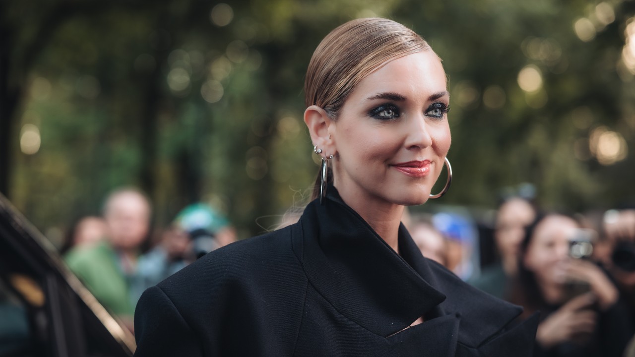 Chiara Ferragni, con i capelli tirati indietro, indossa un cappotto nero. La sua foto vuole riportare il lettore a riflettere sul suo modello societario di gestione di una holding personale.