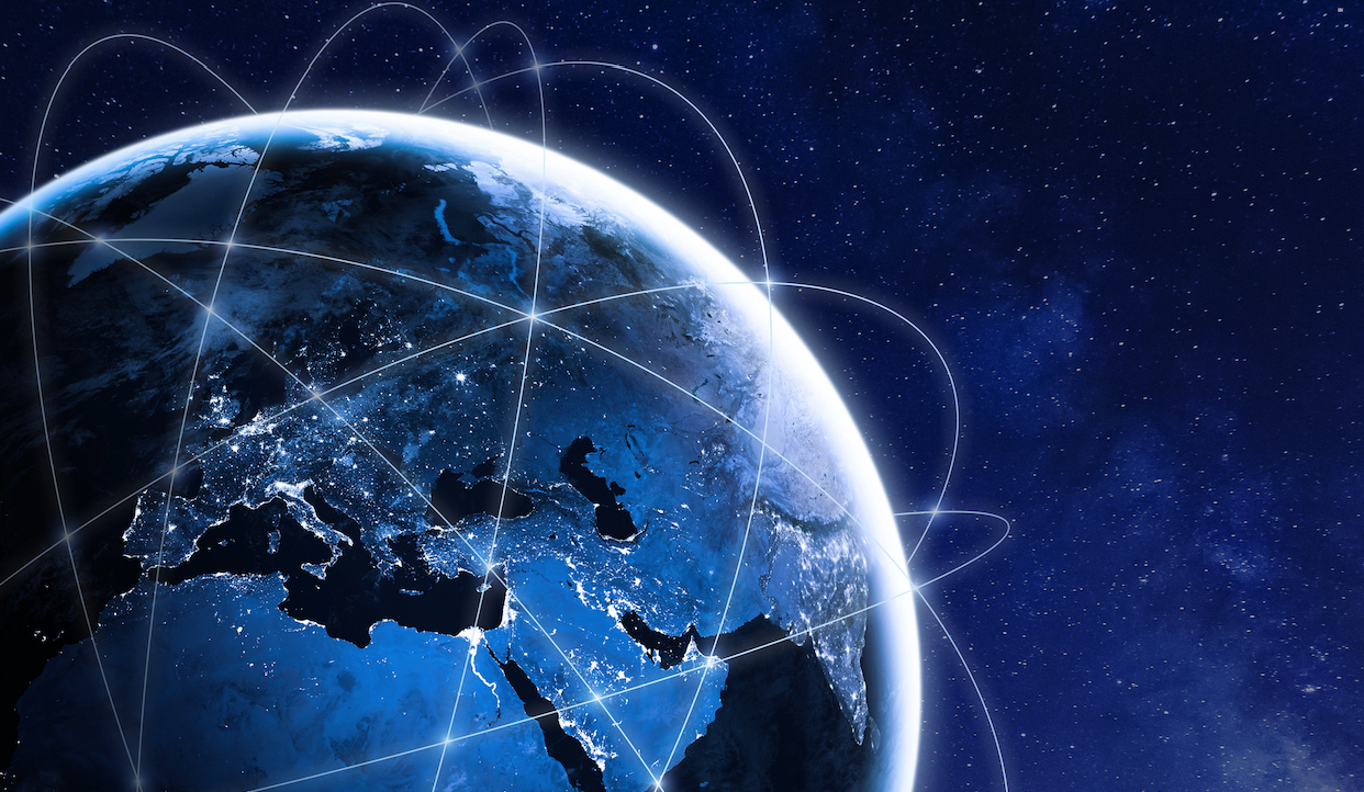 Una vista della Terra dallo spazio che mostra l'Europa, l'Africa e il Medio Oriente di notte, con le luci delle città e le linee curve che rappresentano le connessioni digitali globali in tutto il pianeta.