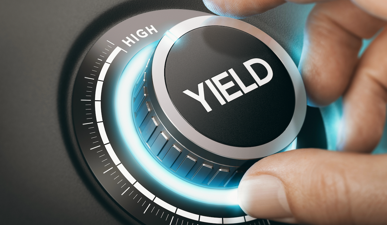 Primo piano di una mano che regola un quadrante etichettato "YIELD" con luce blu brillante. Le impostazioni del quadrante vanno da basso ad alto.