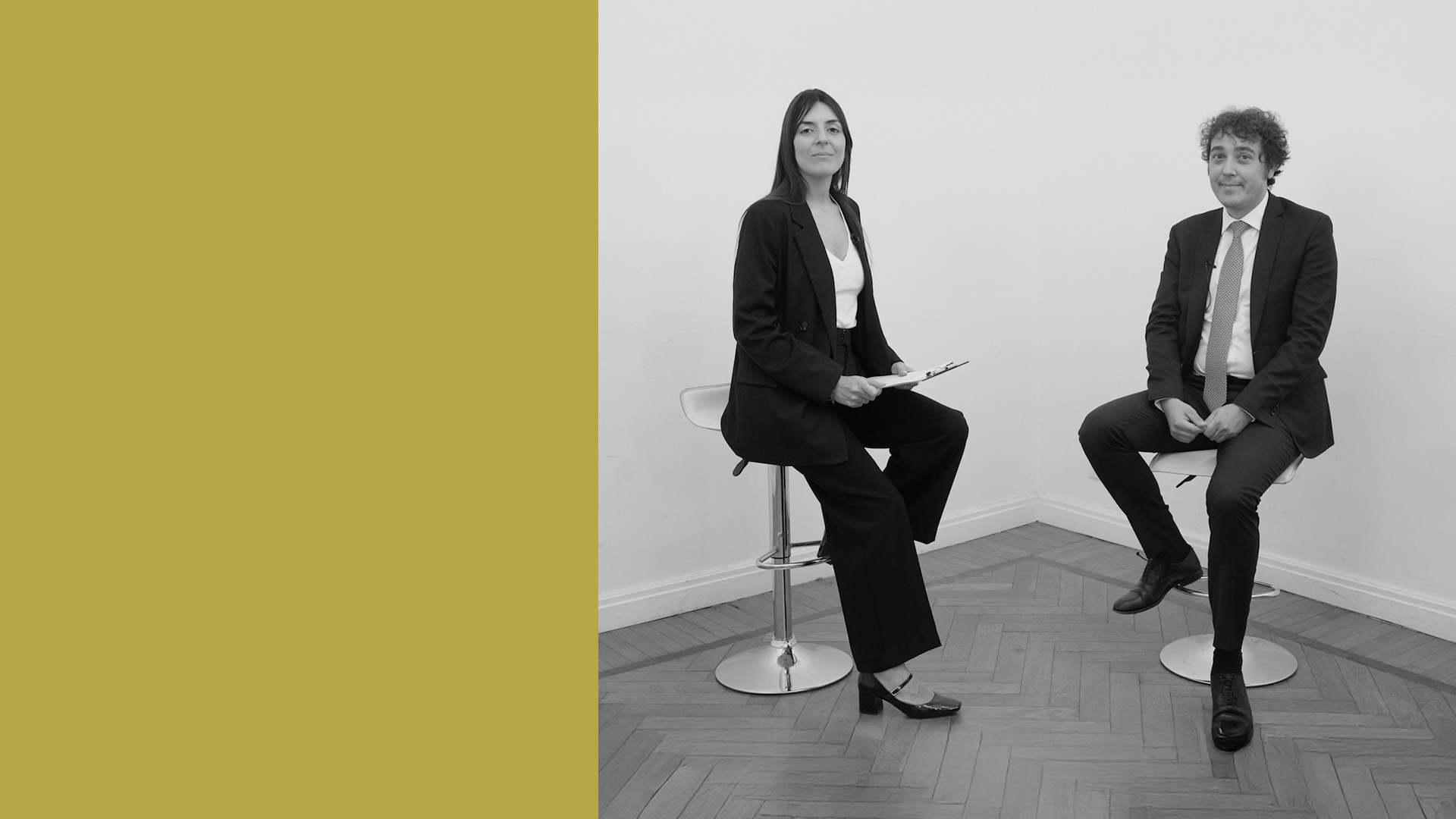 Paola RAgno, giornalista di We Wealth e Stefano Cantù di McKinsey, siedono su sgabelli in una stanza minimalista con pavimento in parquet. Il terzo sinistro dell'immagine è un solido blocco giallo senape.