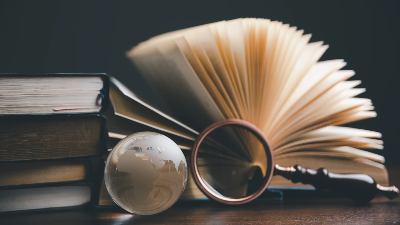 Concetto di assegnazione beni ai soci illustrato con libri di diritto e lente d'ingrandimento.
