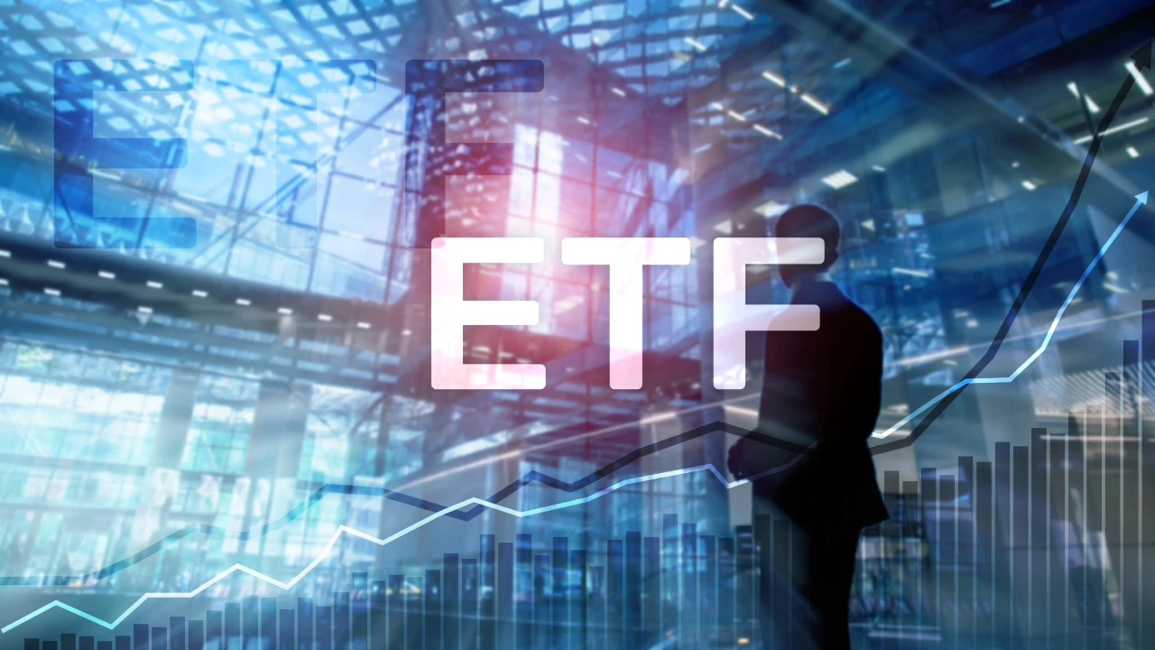 Una grande scritta luminosa "ETF" sovrasta un moderno edificio di vetro con una persona in silhouette, grafici del mercato azionario e linee di grafici finanziari in aumento.