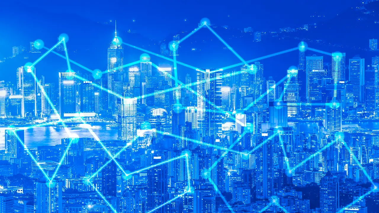 Uno skyline di città vibrante di notte con edifici illuminati, sovrapposti a linee e nodi blu incandescenti che rappresentano reti digitali o concetti di connettività.