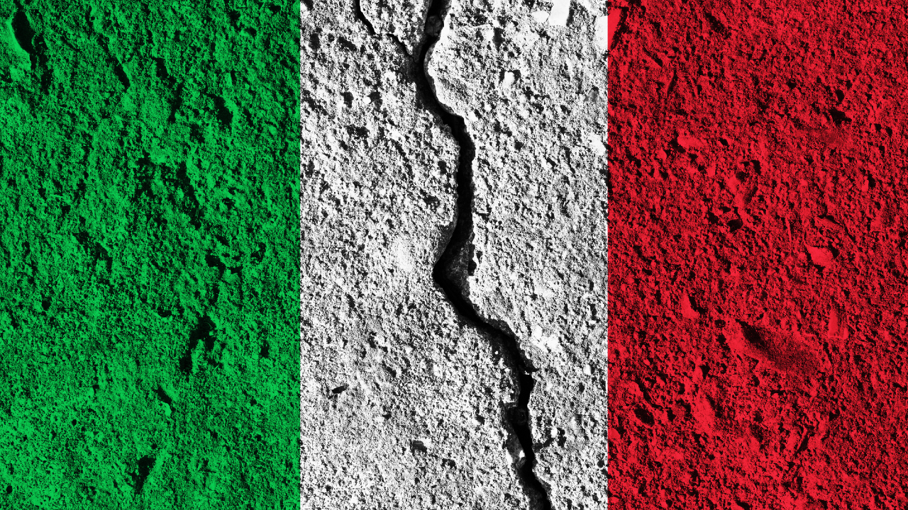 L'immagine mostra la bandiera italiana a strisce verticali verdi, bianche e rosse sovrapposte a una superficie di cemento ruvida e screpolata: una crepa prominente che attraversa la striscia centrale bianca simboleggia la resilienza in mezzo alle discussioni su BTP Valore.