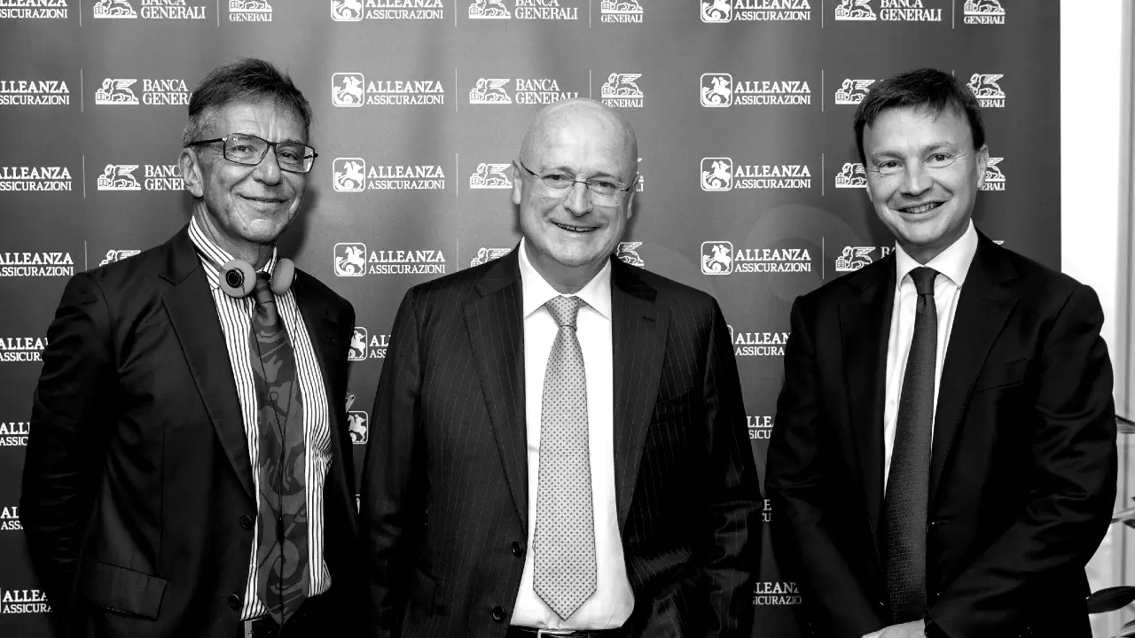 Tre uomini in giacca e cravatta sorridono davanti a un fondale con i loghi di Alleanza Assicurazioni e Banca Generali. L'immagine è in bianco e nero.