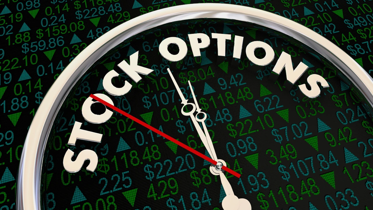 Immagine di un orologio con la scritta "STOCK OPTIONS" sul quadrante, sovrapposto a uno sfondo di prezzi e numeri azionari verdi e blu, da collegare al tema dell'addizionale irpef.