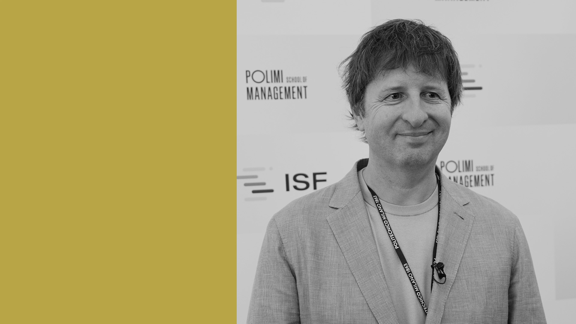 Un uomo sorridente con un blazer chiaro si trova davanti a un fondale con i loghi "POLIMI School of Management" e "ISF"; il lato sinistro dell'immagine ha uno sfondo giallo pieno.