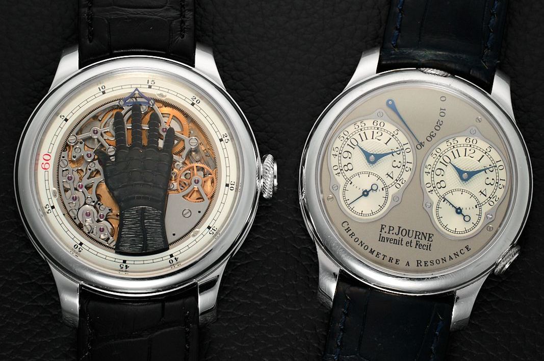 Due orologi da polso di lusso con cinturino nero; l'orologio di sinistra ha un meccanismo aperto e un design nero a forma di mano, mentre l'orologio di destra presenta due quadranti con lancette blu e l'etichetta "F.P. Journe Chronomètre à Résonance".