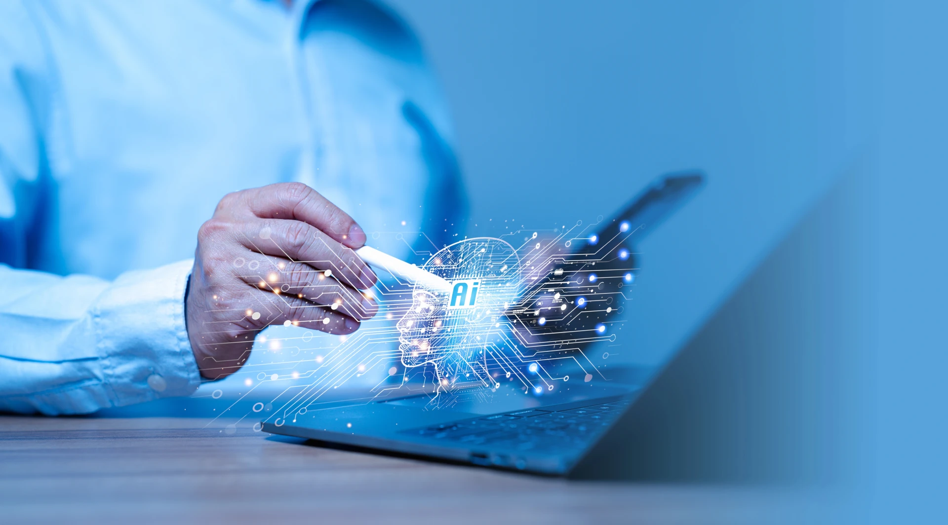 Una persona con uno stilo lavora su un computer portatile, con un'icona digitale dell'intelligenza artificiale luminosa e linee di circuito sovrapposte, che rappresentano l'intelligenza artificiale e l'integrazione tecnologica.