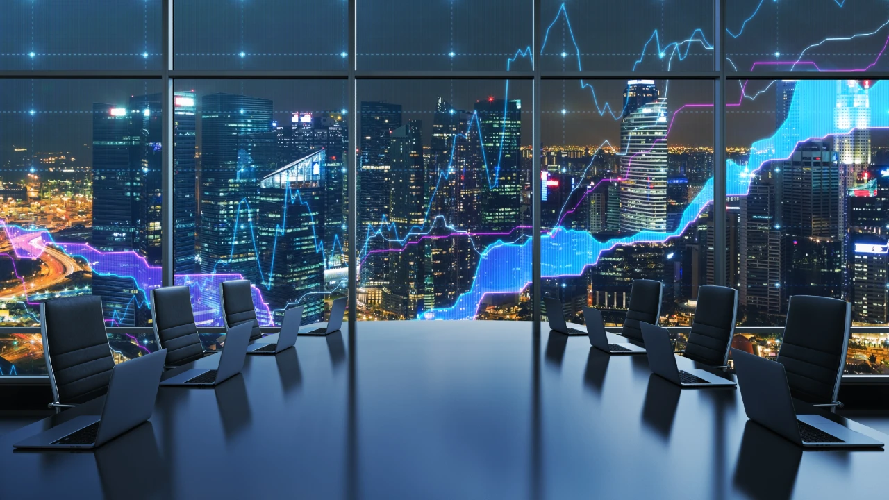 A modern conference room with empty chairs and laptops overlooks a city skyline at night, with digital graphs and stock market charts superimposed on the windows.