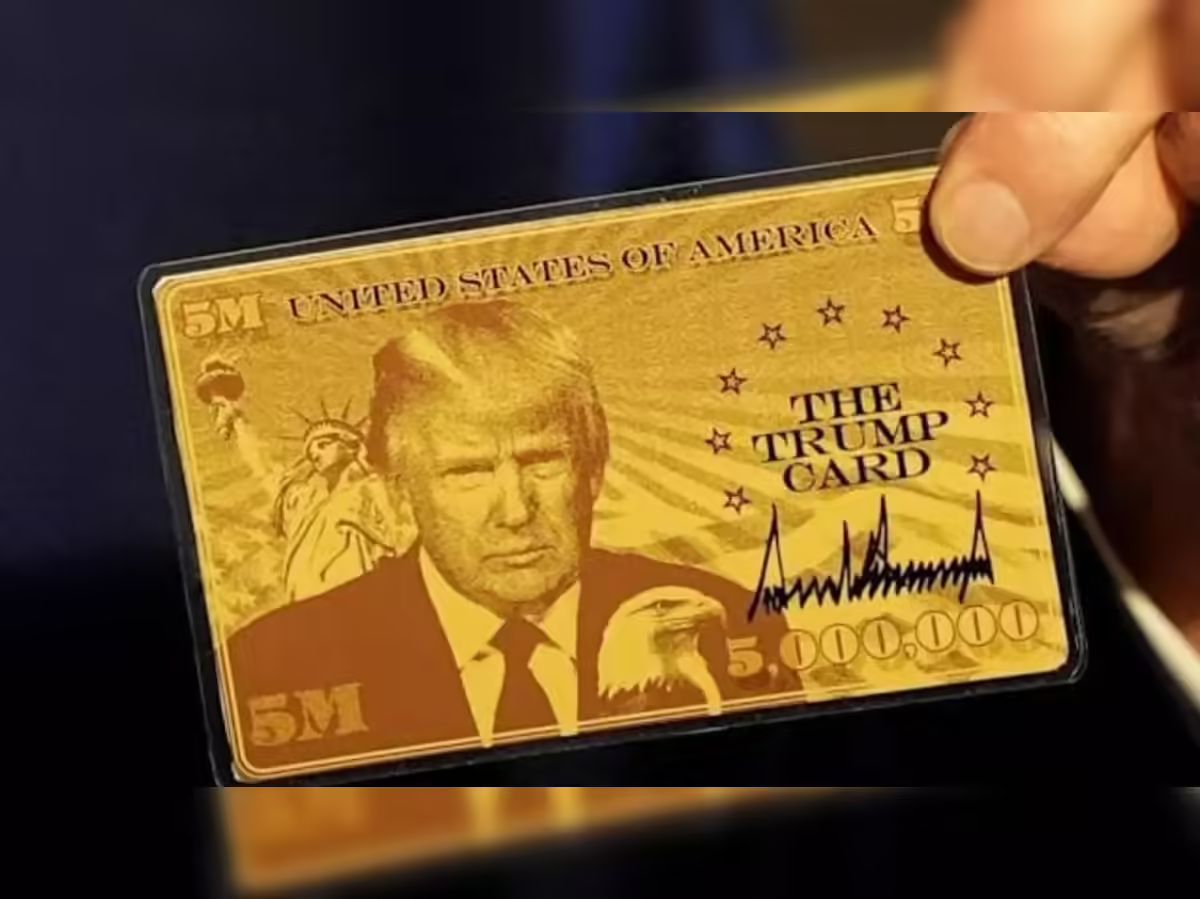 Una mano tiene un biglietto color oro con l'immagine di Donald Trump, un'aquila calva, la Statua della Libertà e il testo "THE TRUMP CARD", oltre a "5M" e "UNITED STATES OF AMERICA".