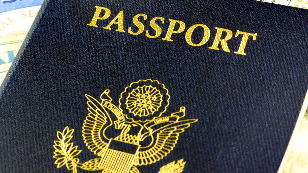 Un primo piano della copertina di un passaporto statunitense, spesso ricercato attraverso i programmi di visto d'oro, che mostra la scritta in oro "PASSPORT" e parte dell'emblema ufficiale dell'aquila. Il riferimento va ai golden visa.