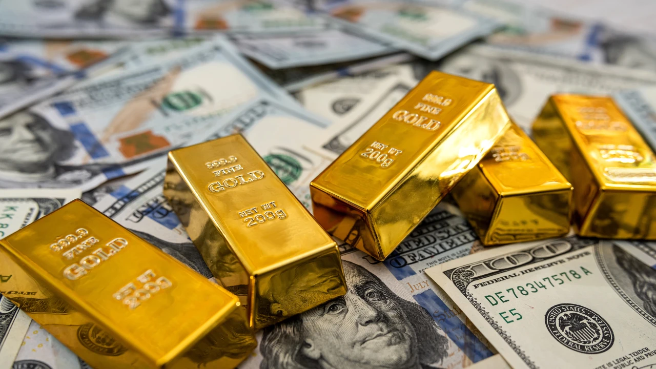 Lingotti d’oro appoggiati su banconote da 100 dollari USA, simbolo del rialzo simultaneo di oro e mercati azionari segnalato dal BIS.