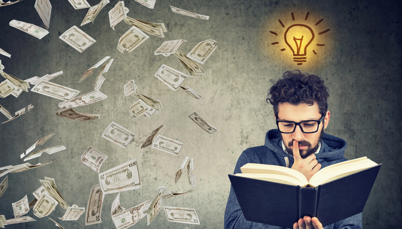 Un uomo con gli occhiali legge pensieroso un libro mentre intorno a lui fluttuano banconote da un dollaro. Sopra la sua testa appare l'icona di una lampadina incandescente, che simboleggia un'idea o un'ispirazione su come guadagnare soldi.