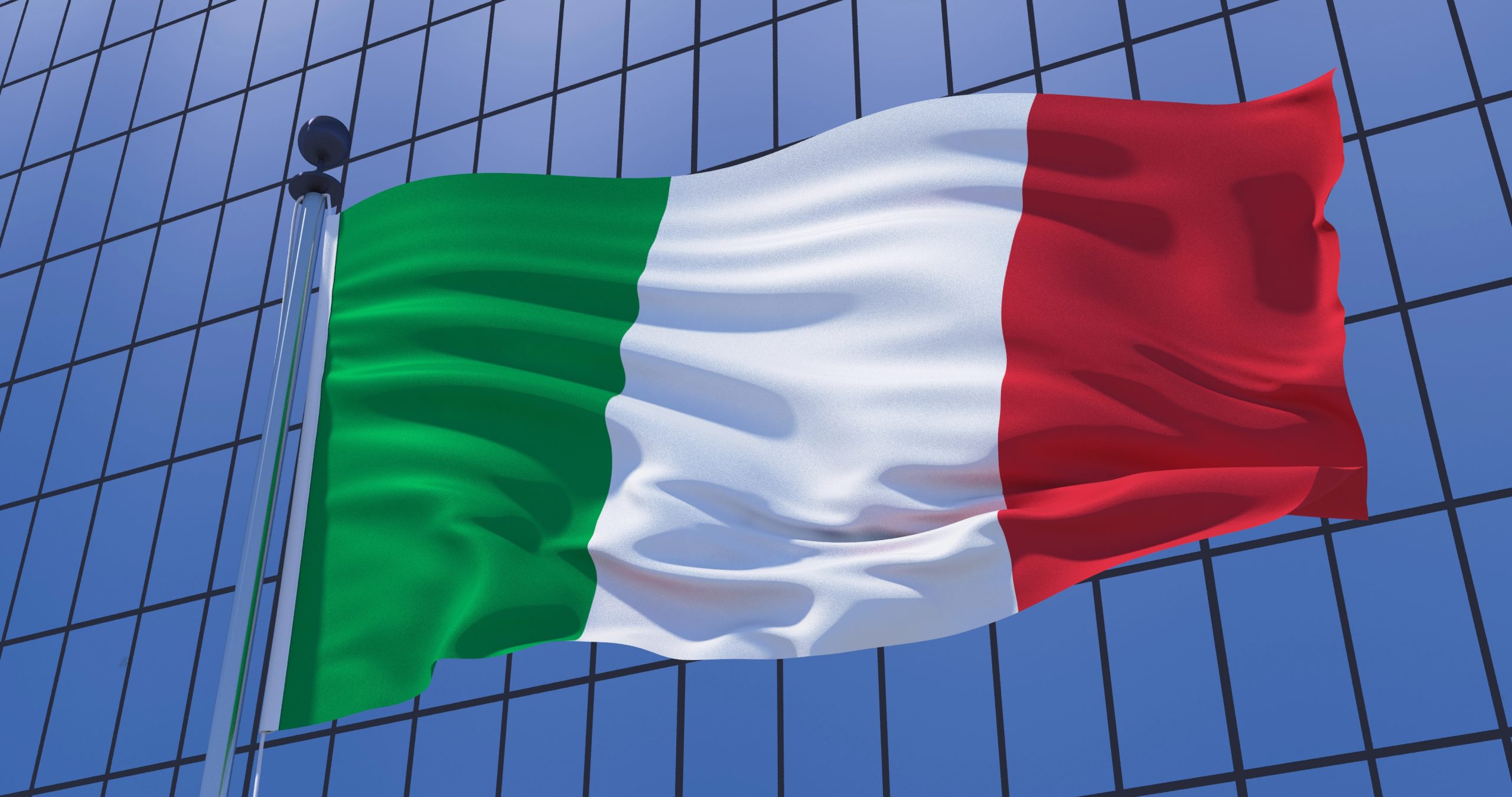 Bandiera italiana davanti a un edificio moderno, simbolo del contesto economico e finanziario del mercato italiano