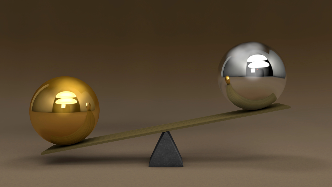 Bilancia con due sfere metalliche di colore diverso, in equilibrio, a rappresentare il confronto tra valore e quantità nel mercato M&A del wealth management.