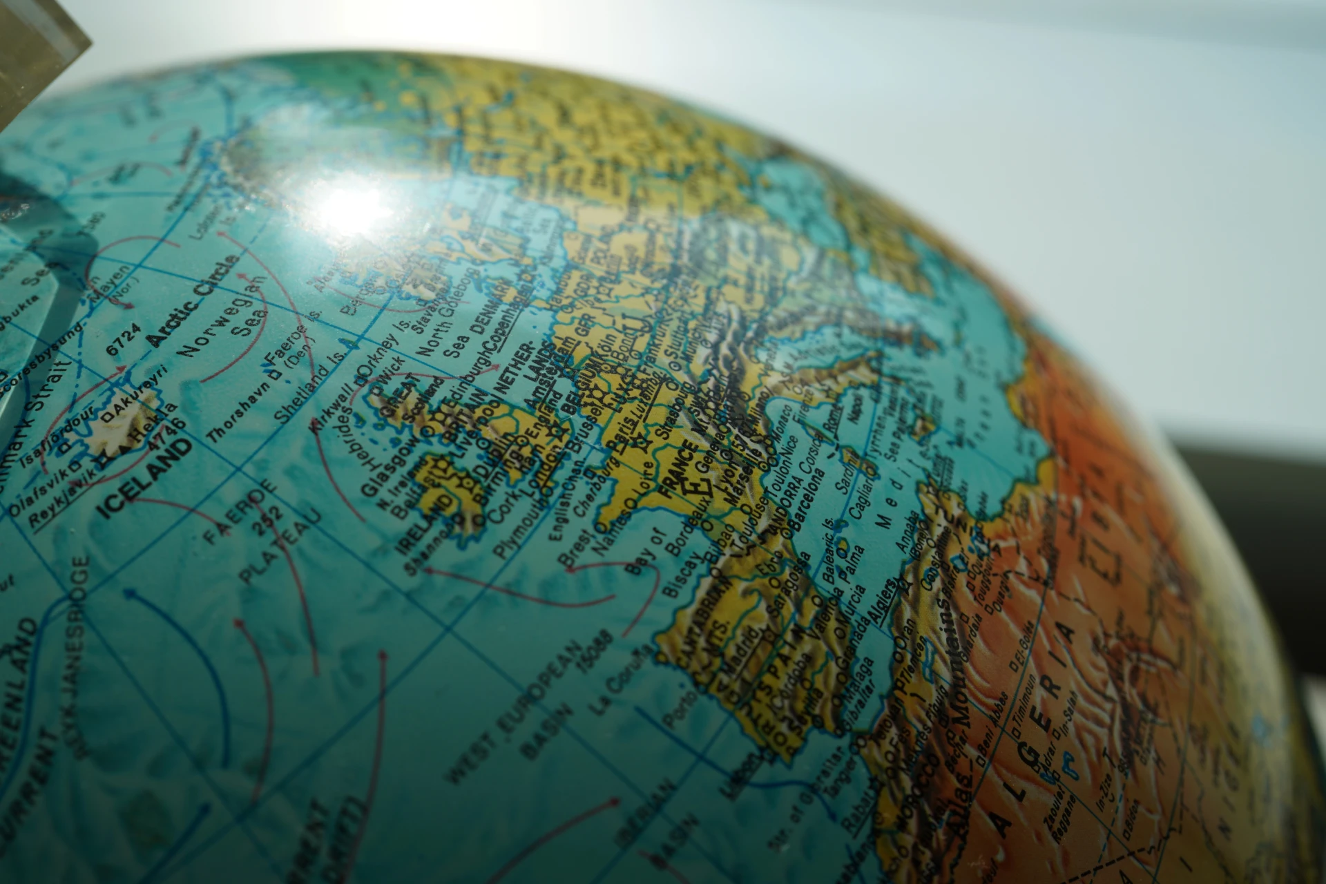 Un primo piano di un mappamondo che mostra parti dell'Europa occidentale, tra cui Regno Unito, Francia, Spagna e paesi vicini, con la luce del sole che si riflette sulla superficie: ideale per illustrare i mercati globali del reddito fisso.