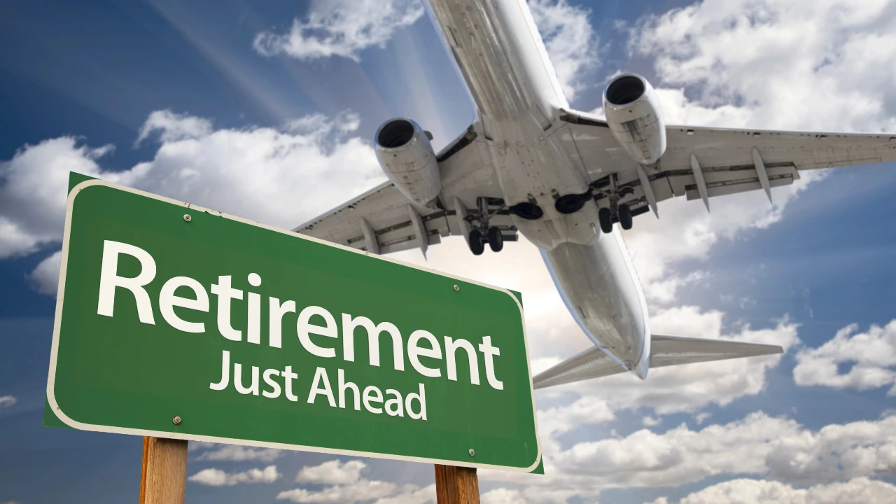 A large airplane flies overhead in a partly cloudy sky, while a green road sign in the foreground reads "Retirement Just Ahead," symbolizing the exciting journey of retiring and new adventures on the horizon.