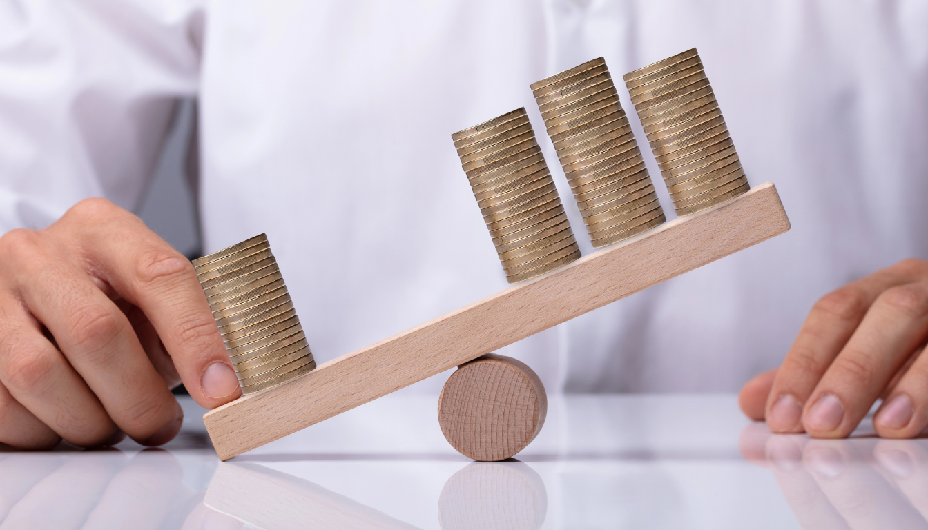 Rappresentazione della leva finanziaria nel trading: una bilancia in legno con monete che illustra l'effetto moltiplicatore del capitale.