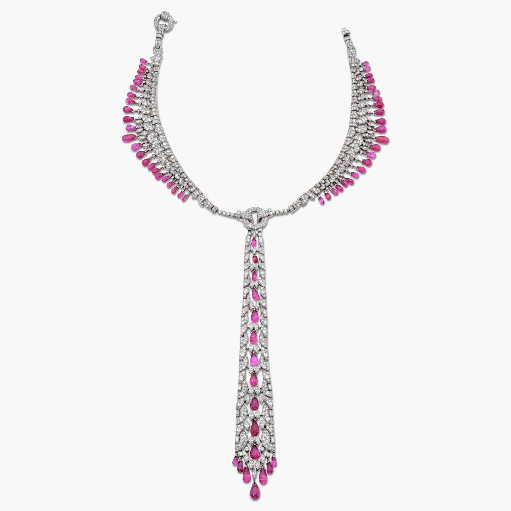 Collana d'argento con diamanti e pendenti a goccia rosa su sfondo bianco.